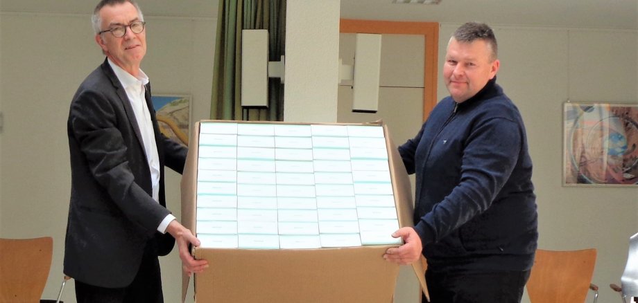 Franz Jirasek nimmt einen großen Karton mit 950 Masken entgegen.