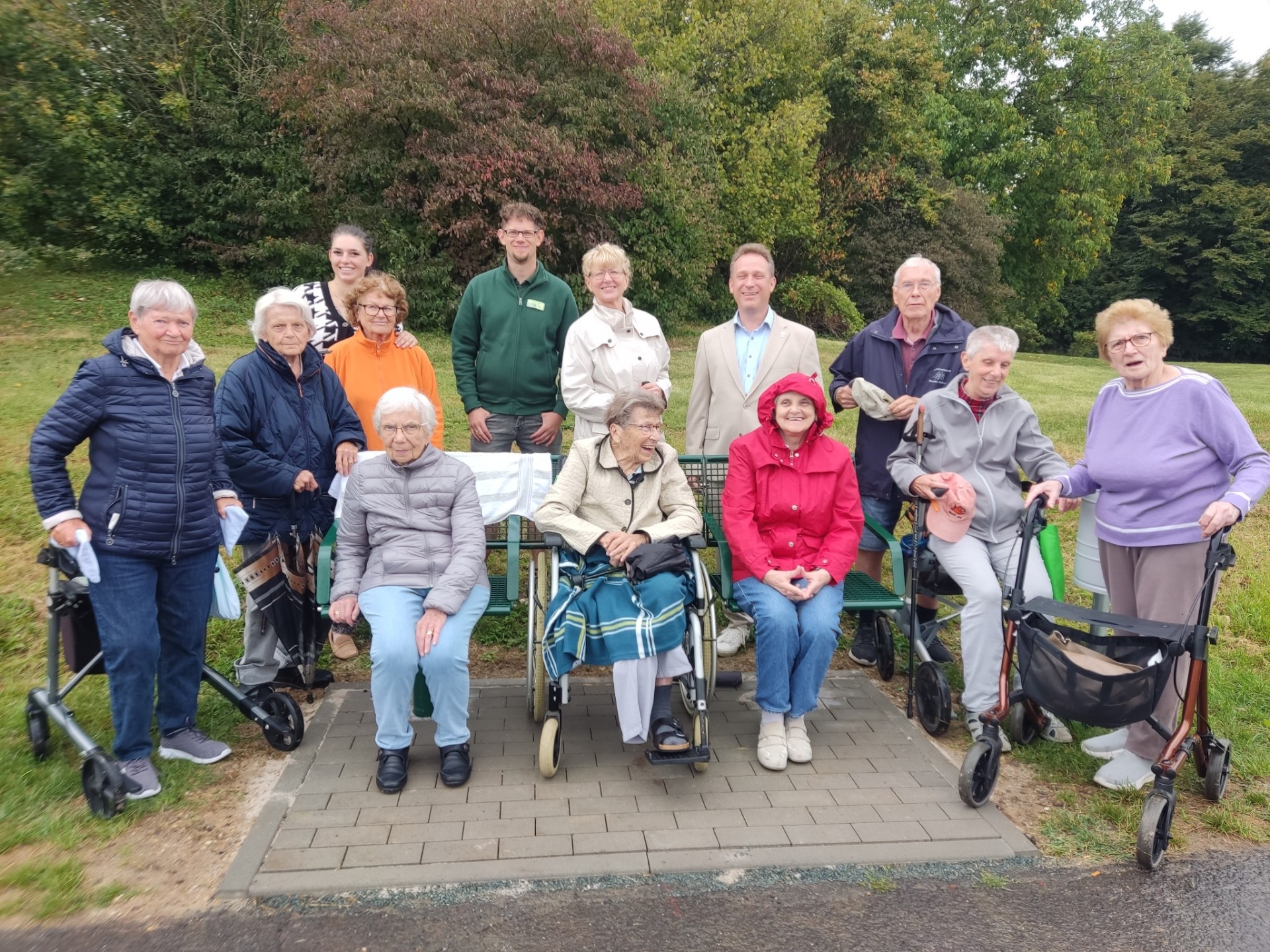 Eine Gruppe Senioren, Spender und der Erste Beigeordnete rund um die neue Bank.