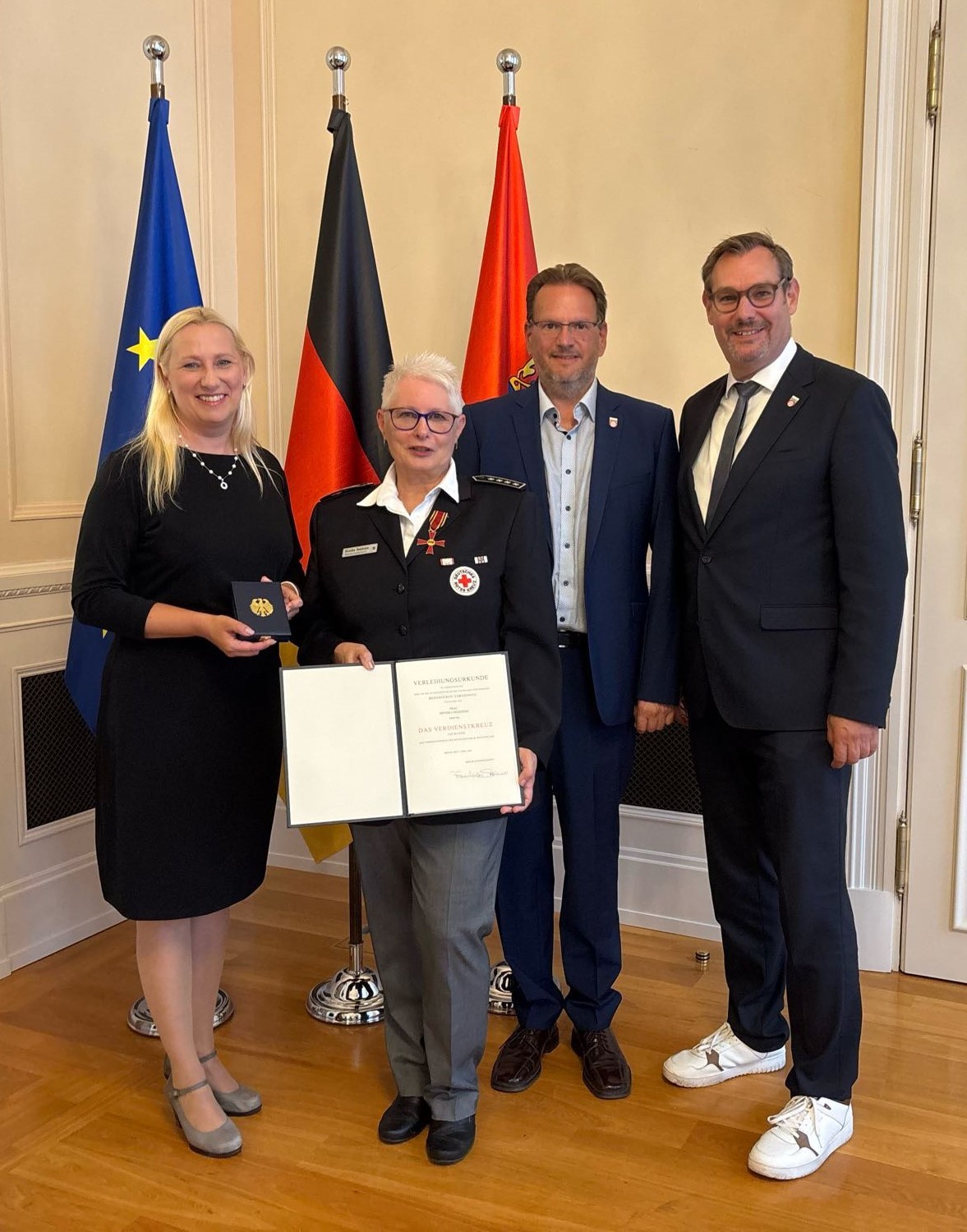 Monika Beisheim im Ministerium mit Bundesverdienstkreuz und der Urkunde.