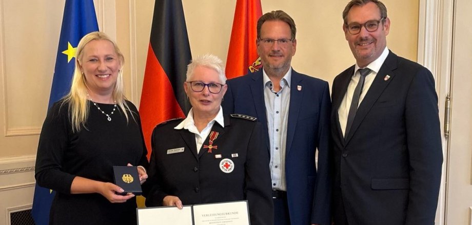 Monika Beisheim im Ministerium mit Bundesverdienstkreuz und der Urkunde.