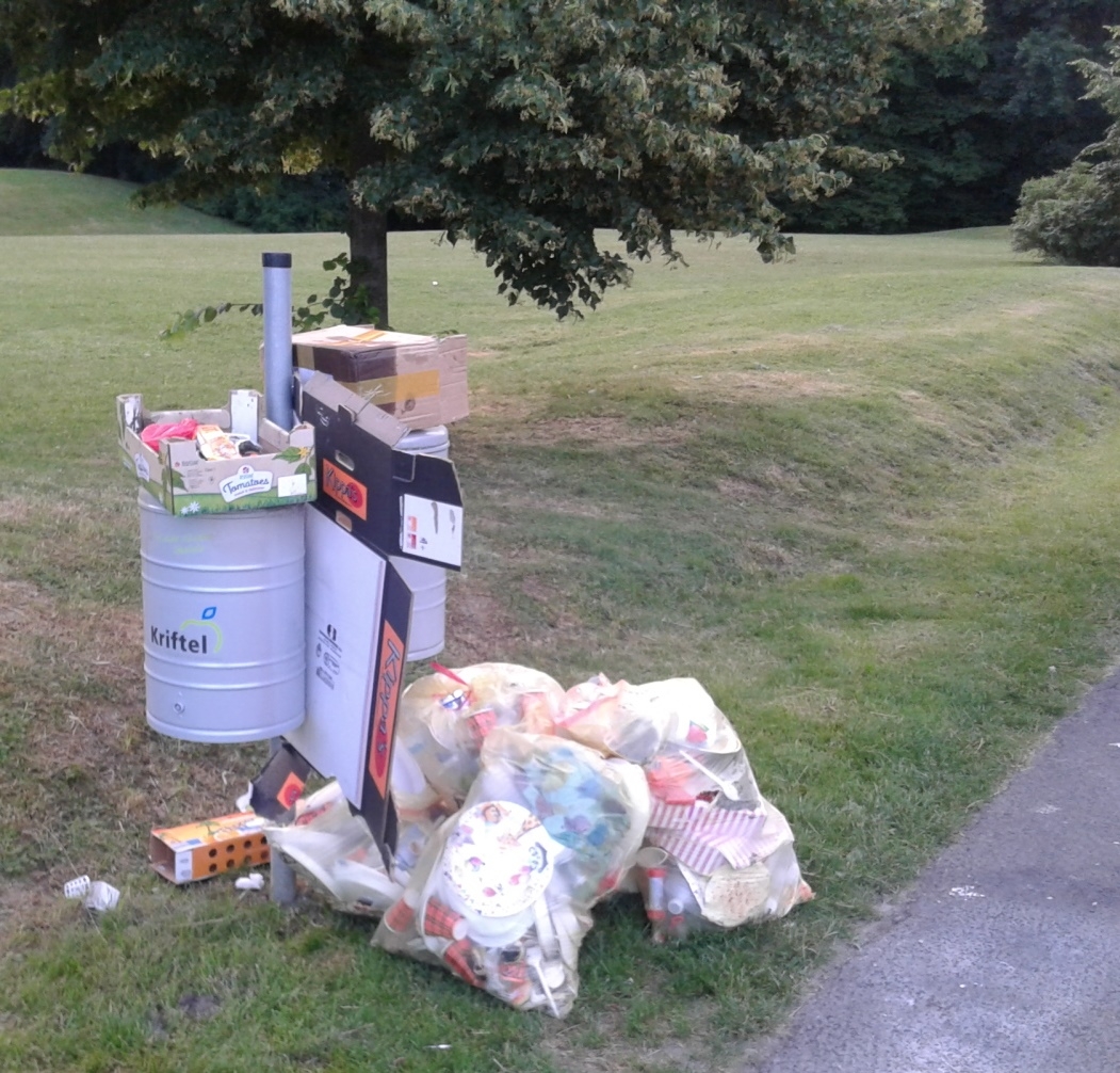 Überfüllte Mülltonne im Freizeitpark.