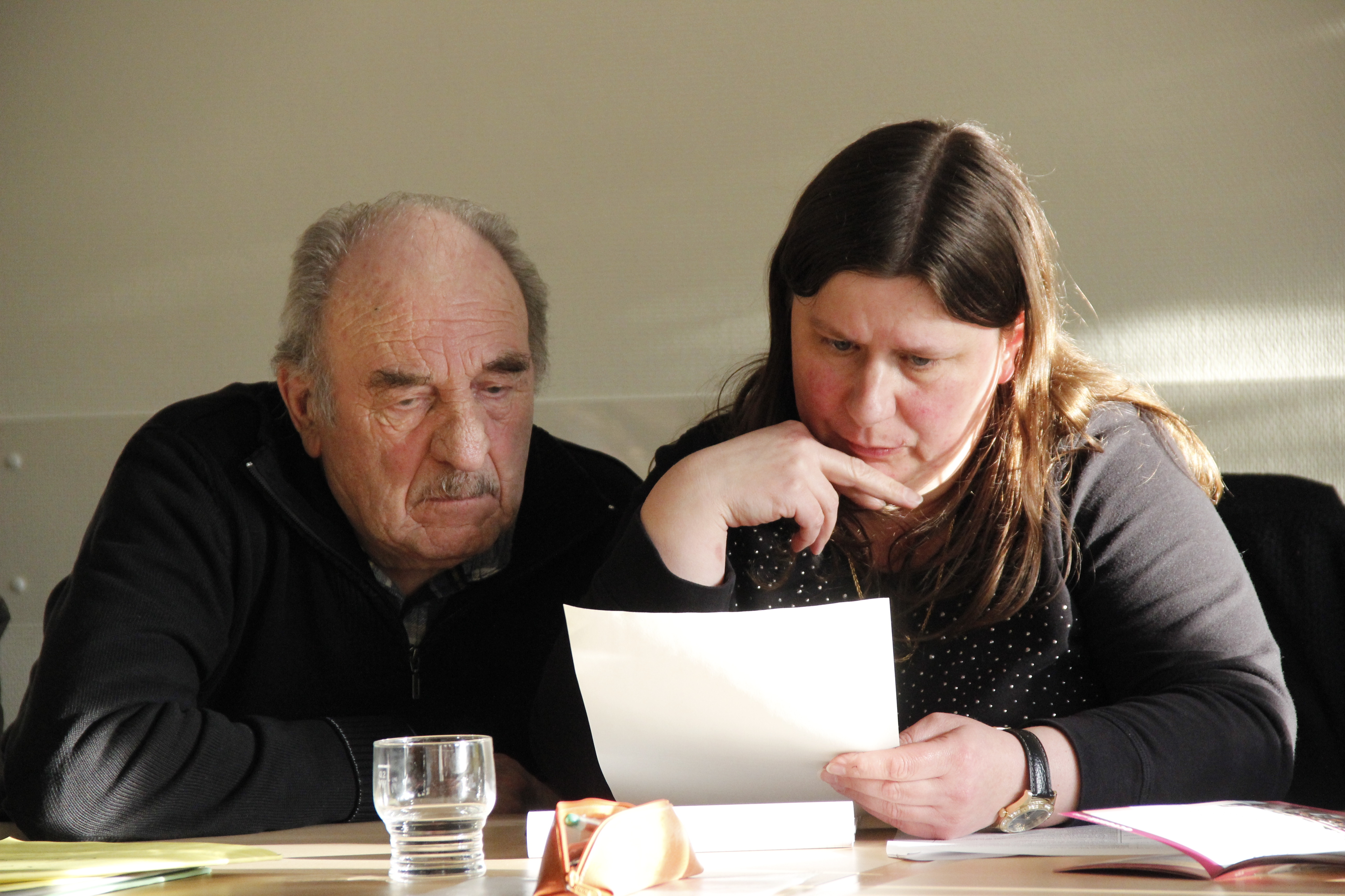 Hubert Bonard mit Kollegin über Akten oder Programmheft gebeugt.