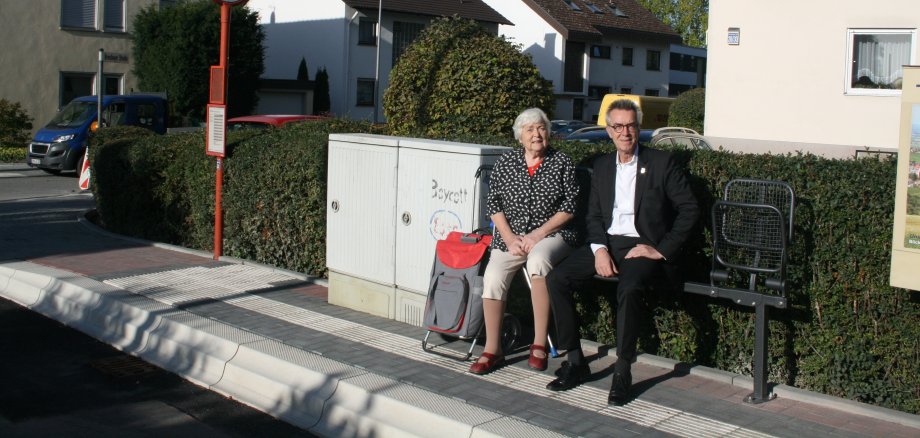 Der Erste Beigeordnete Franz Jirasek sitzt neben Anwohnerin Rosemarie Fiedler auf einer neuen Klappbank.