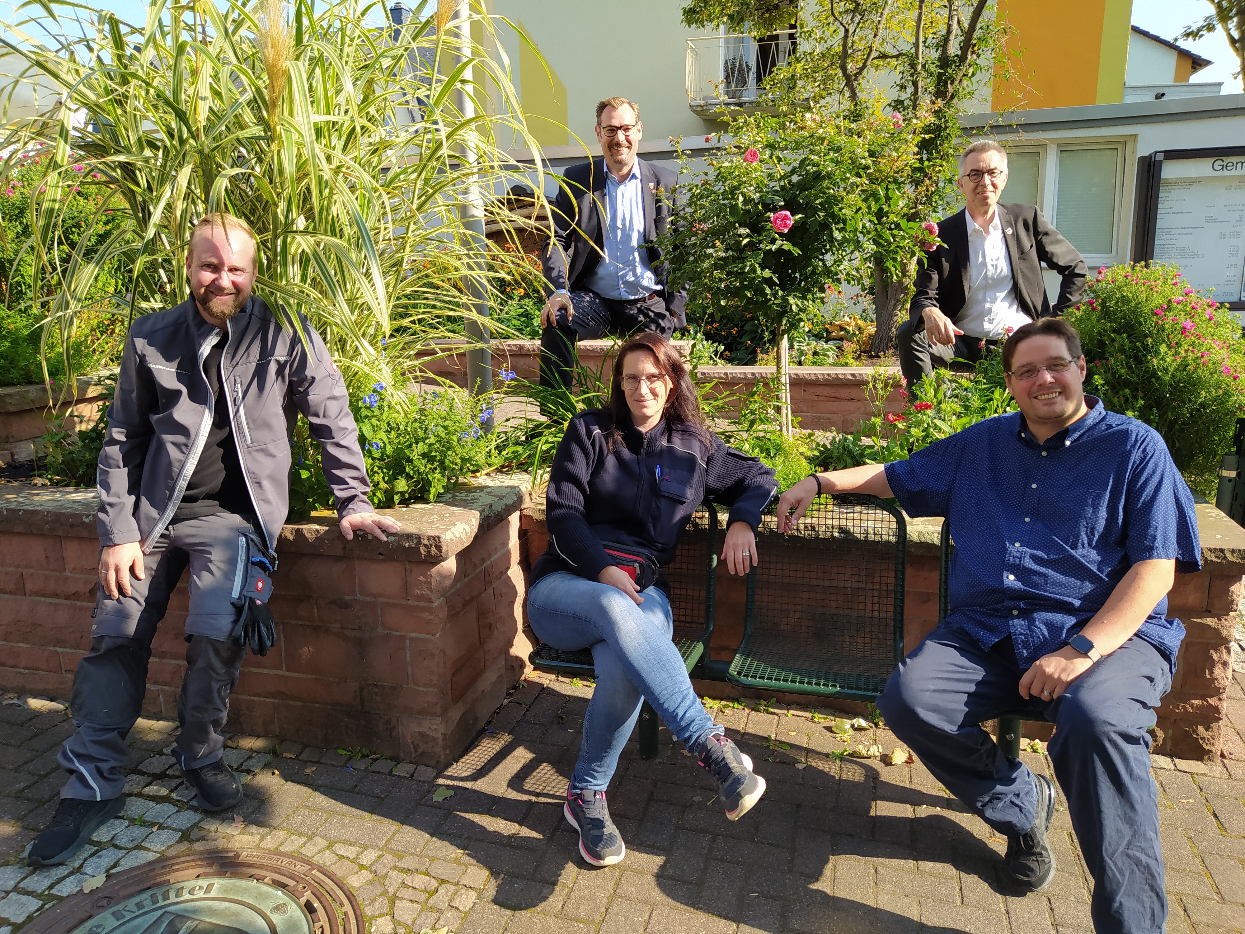 Die neuen Mitarbeiter mit den Rathauschefs vor dem Beet am Rathaus-Entree.