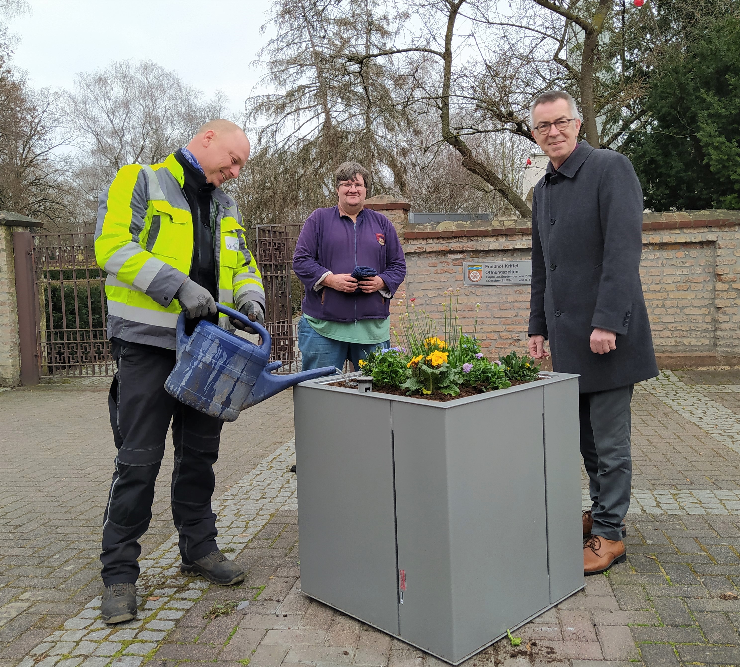 Franz Jirasek und das Pflanzteam neben dem neuen Pflanzkübel.