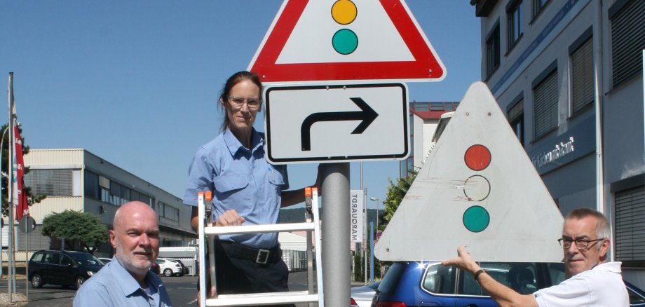 Die Hilfspolizisten mit einem neuen und einem alten Ampelschild.
