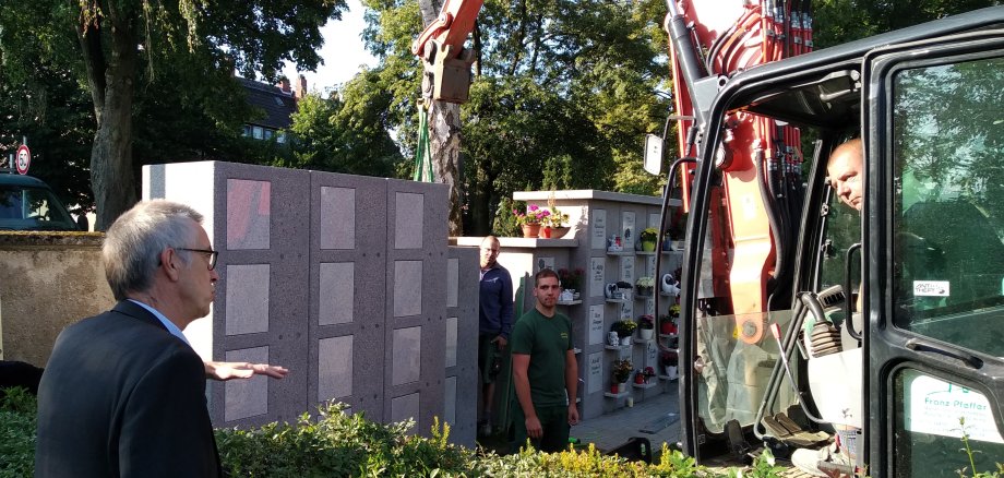Franz Jirasek schaut bei der Aufstellung der Urnenwand per Kran zu.