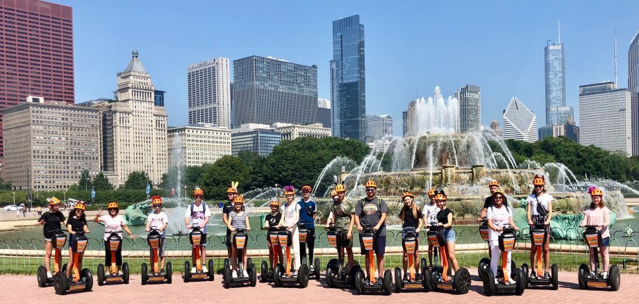 Schüler auf Segways vor der Skyline Chicagos.