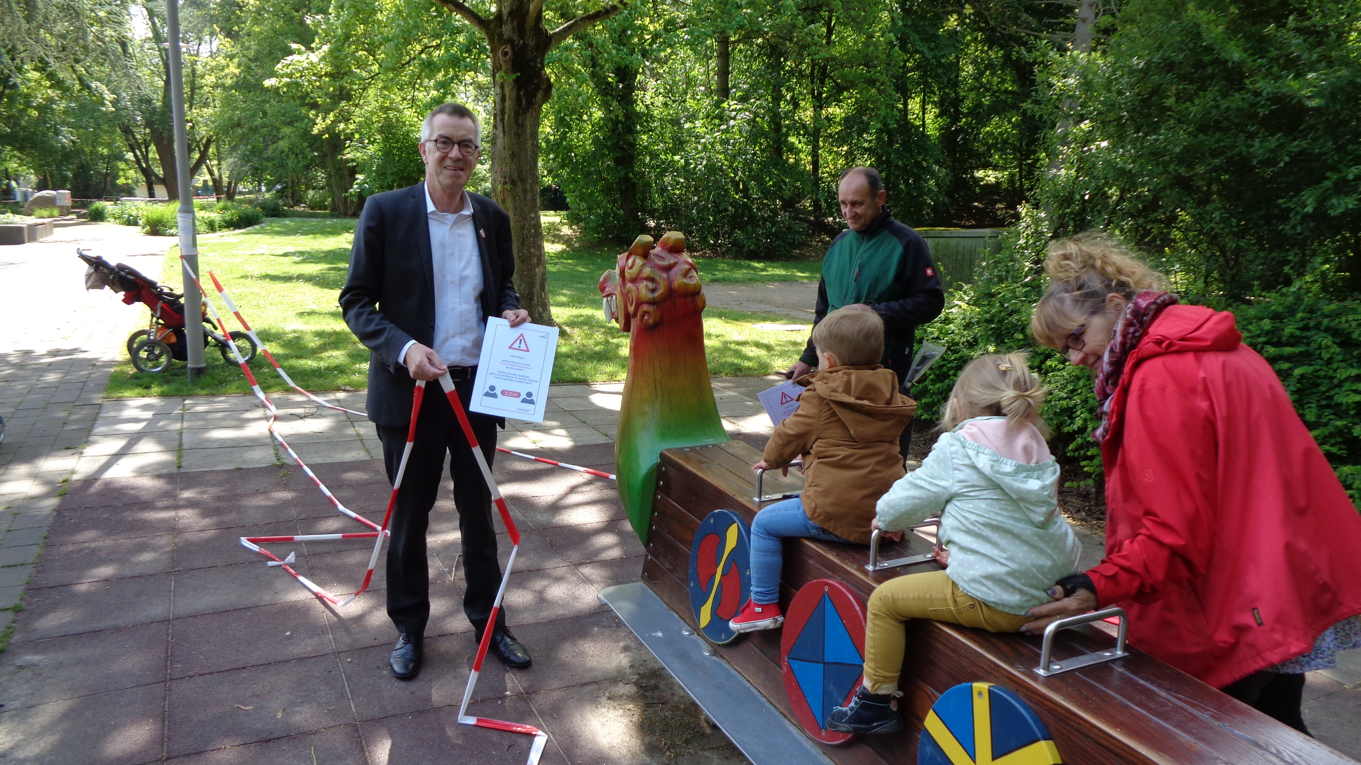 Franz Jirasek vpor dem Drachen im Freizeitpark. Er entfernt Flatterband, Kids sitzen schon auf dem Spielgerät.