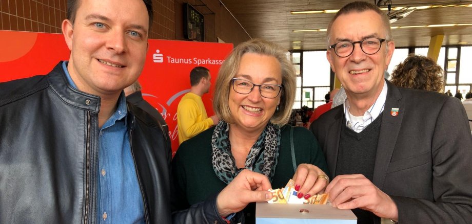 Der Erste Beigeordnete Franz Jirasek steht mit den Bürgermeistern aus Hofheim und Liederbach am Spendentopf.