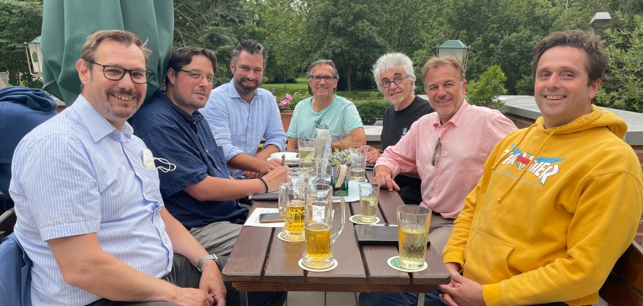 Das Orgateam an einem Tisch auf der Schwarzbachhallen-Terrasse.