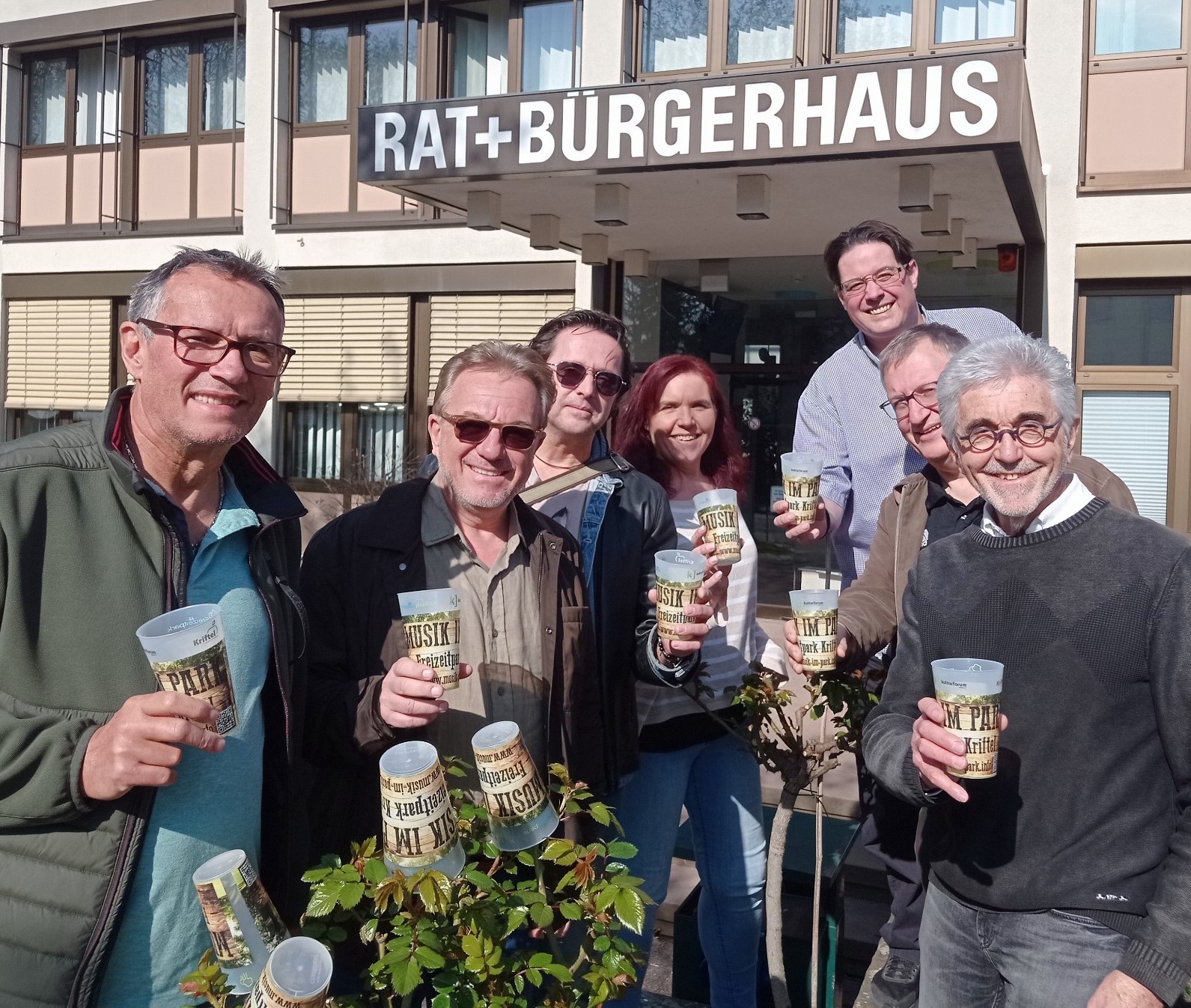 Das Orgateam mit Festivalbechern vor dem Rathaus.