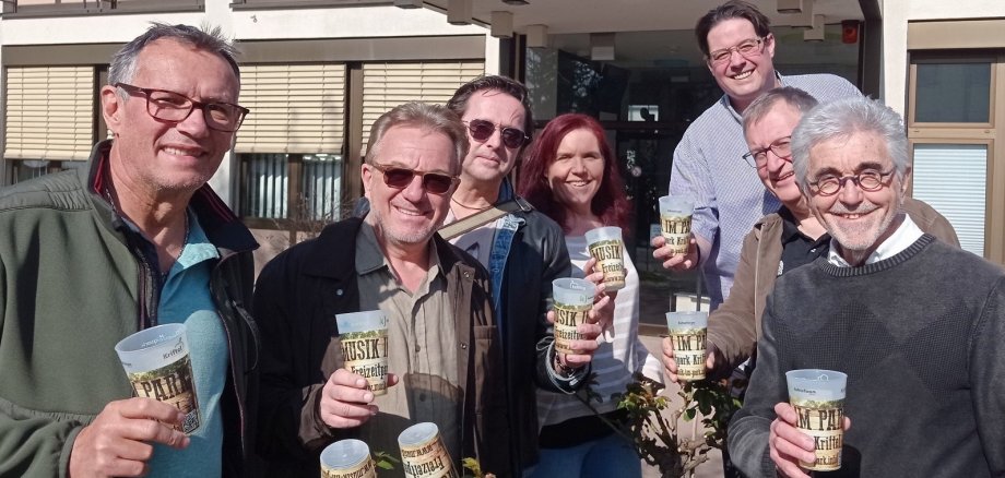 Das Orgateam mit Festivalbechern vor dem Rathaus.