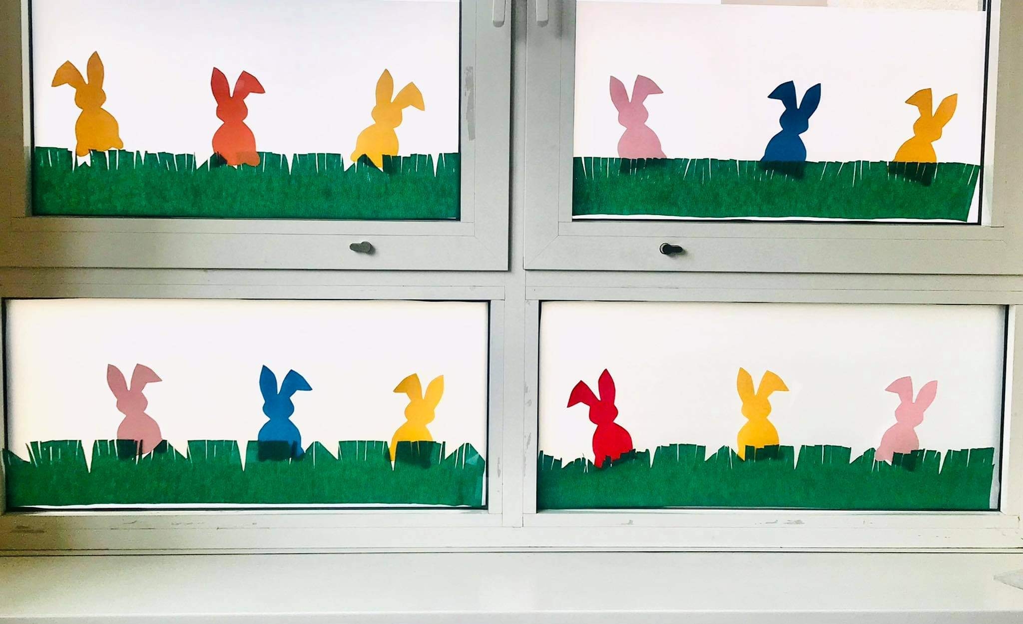 Bunte Hasen im Fenster.