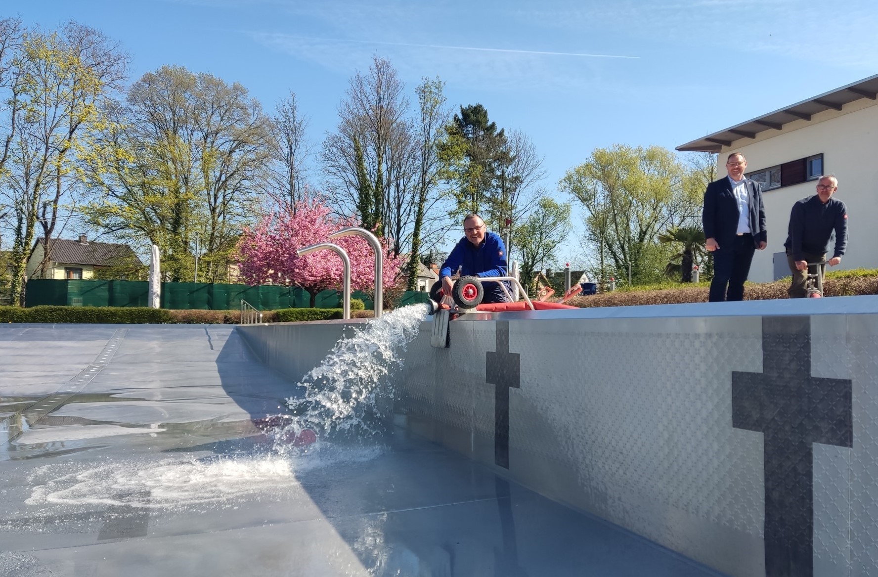 Schwimmmeister lassen das Wasser ins Becken.