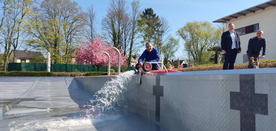 Schwimmmeister lassen das Wasser ins Becken.