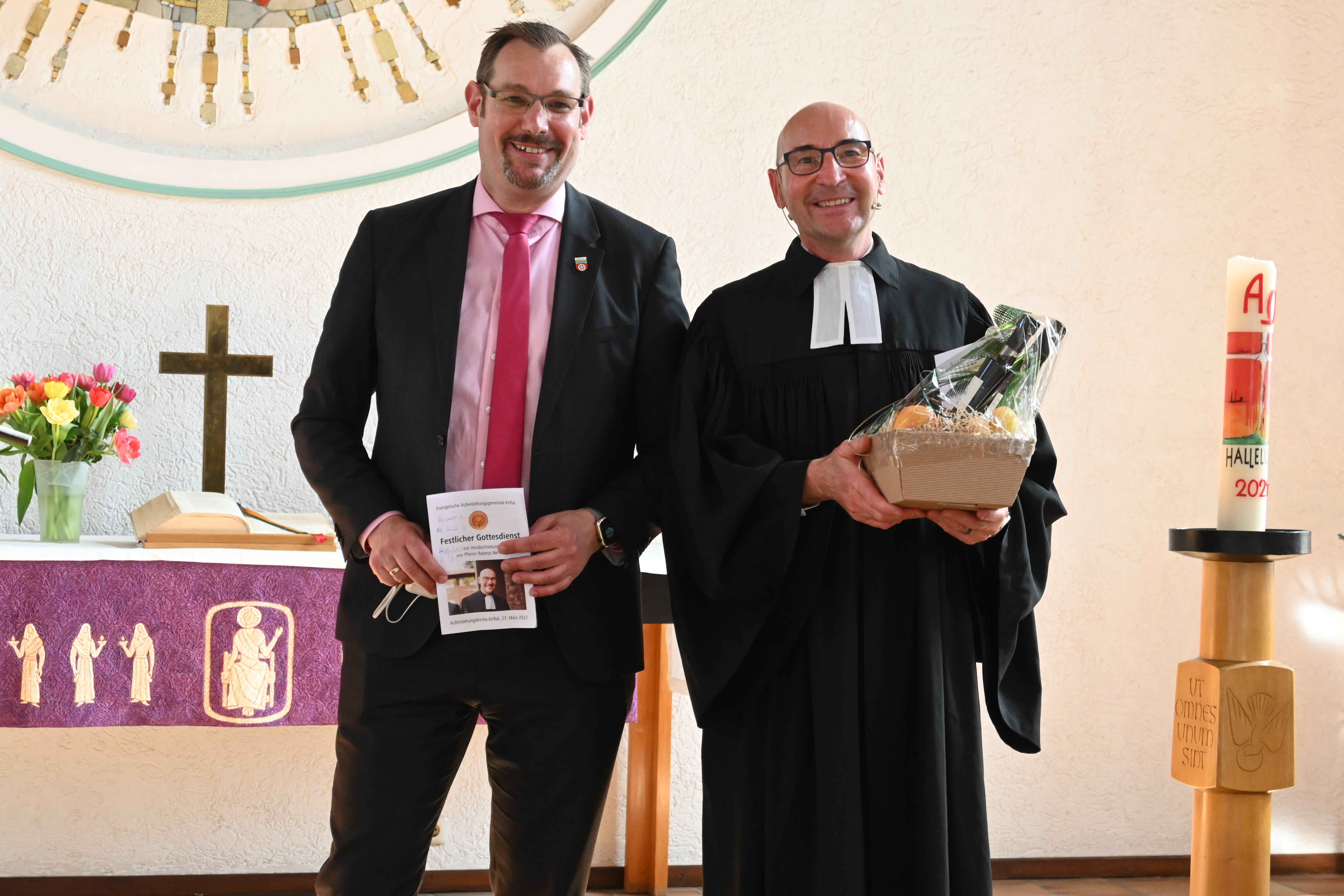 Christian Seitz und Pfarrer Bertram mit einem Geschenk in der Kirche.