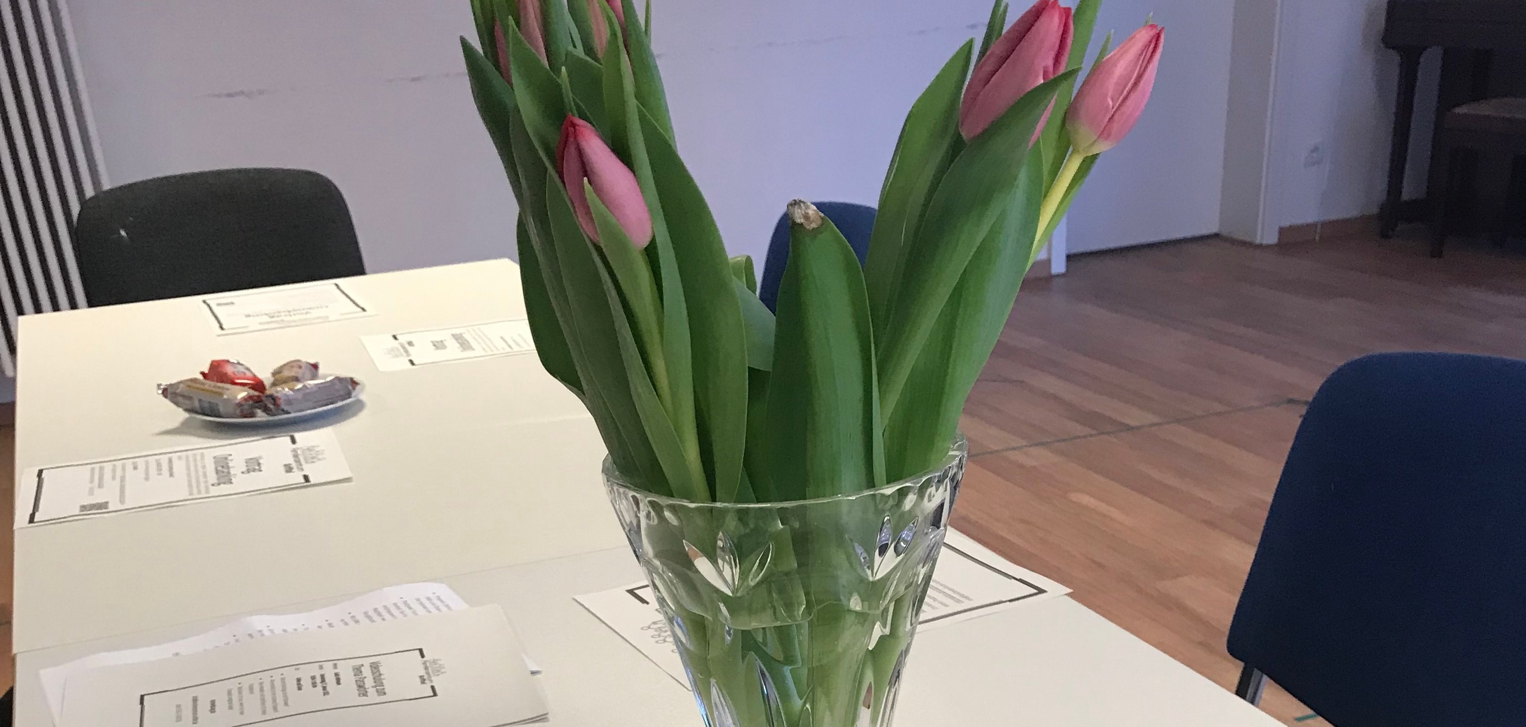 Das Programm auf einem Tisch mit Blumenstrauß.