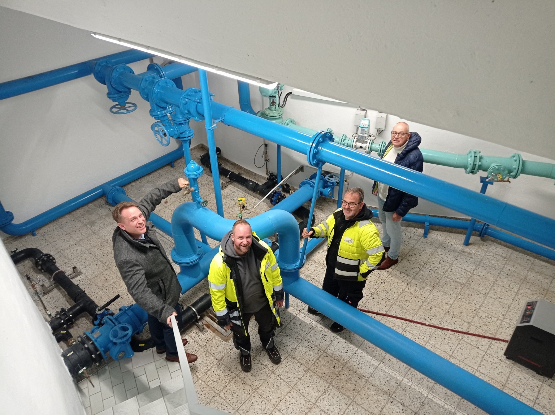 Wassermeister neben Wasserrohren.