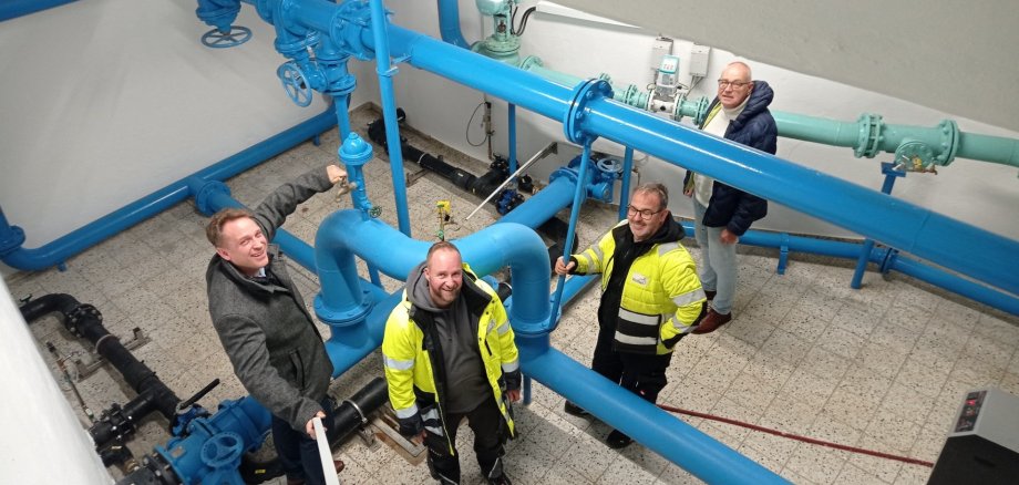 Wassermeister neben Wasserrohren.