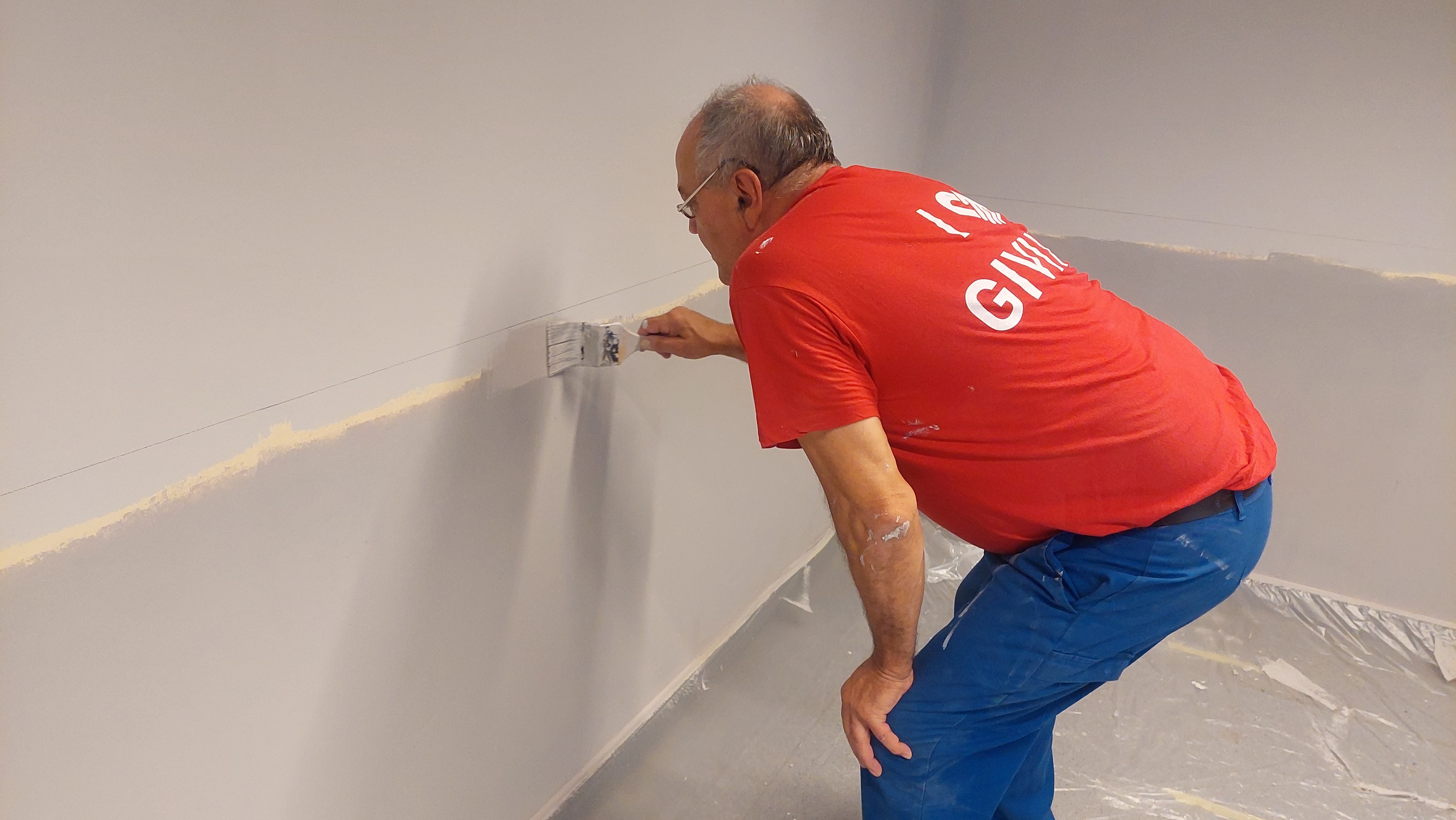 Ein Mann streicht eine Wand.