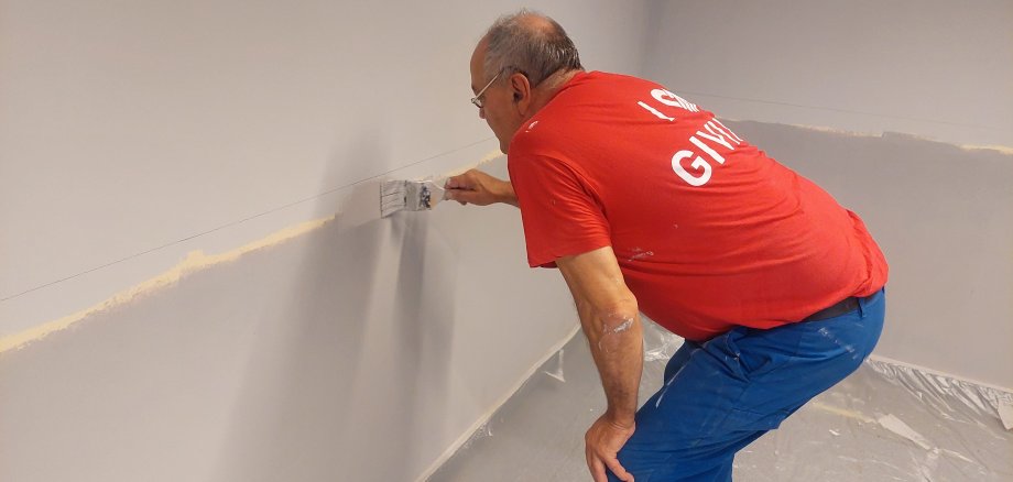 Ein Mann streicht eine Wand.
