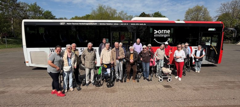 Eine Gruppe Rollator-Fahrer vor einem Linienbus.