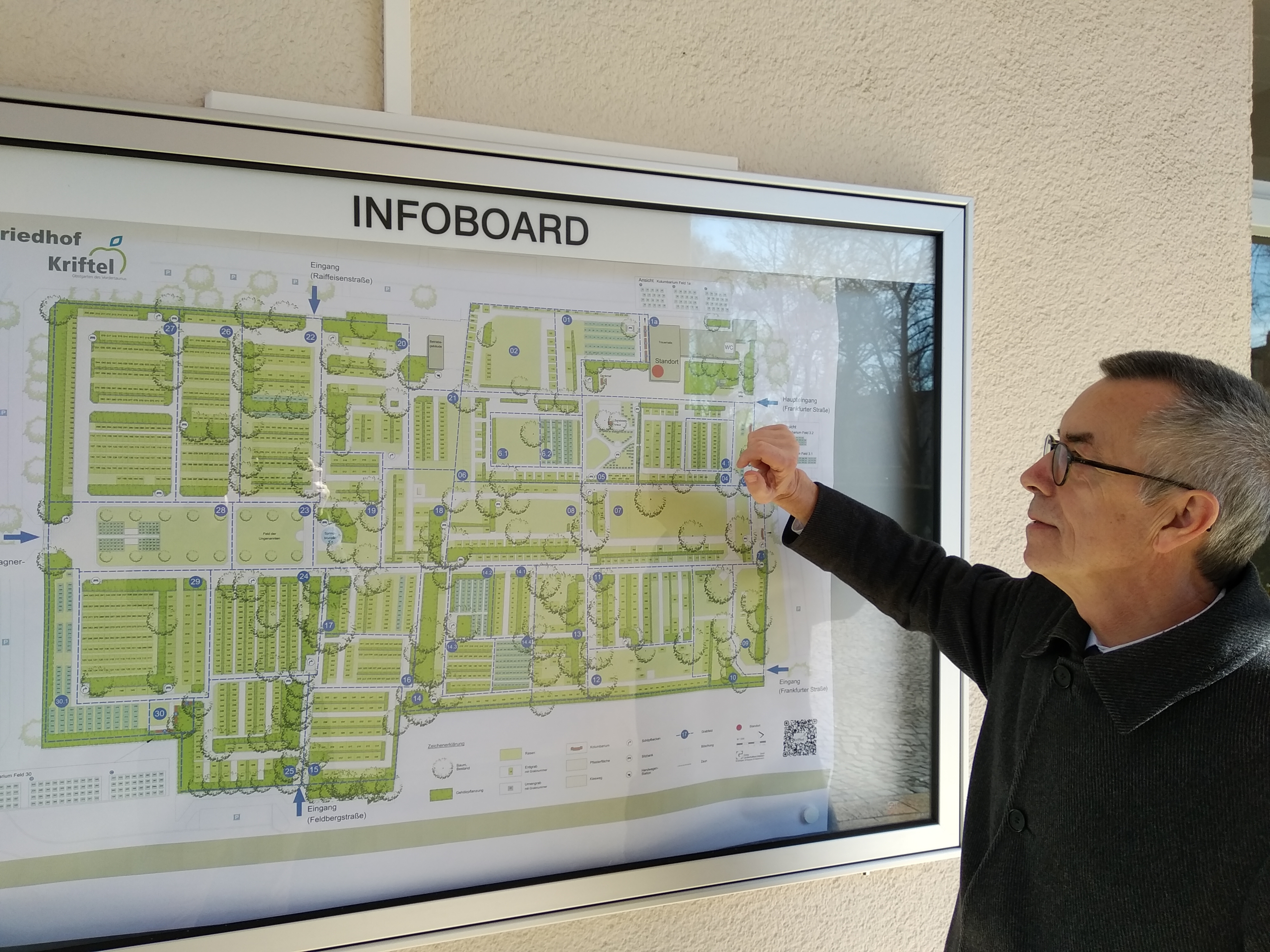 Franz Jirasek betrachtet den großen Übersichtsplan, der in einem Schaukasten an der Trauerhalle hängt.