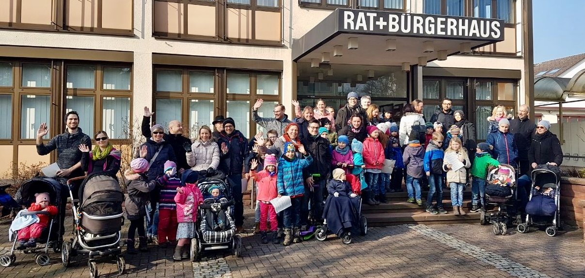 Viele Familien mit Winterkleidung vor dem Rat- und Bürgerhaus.