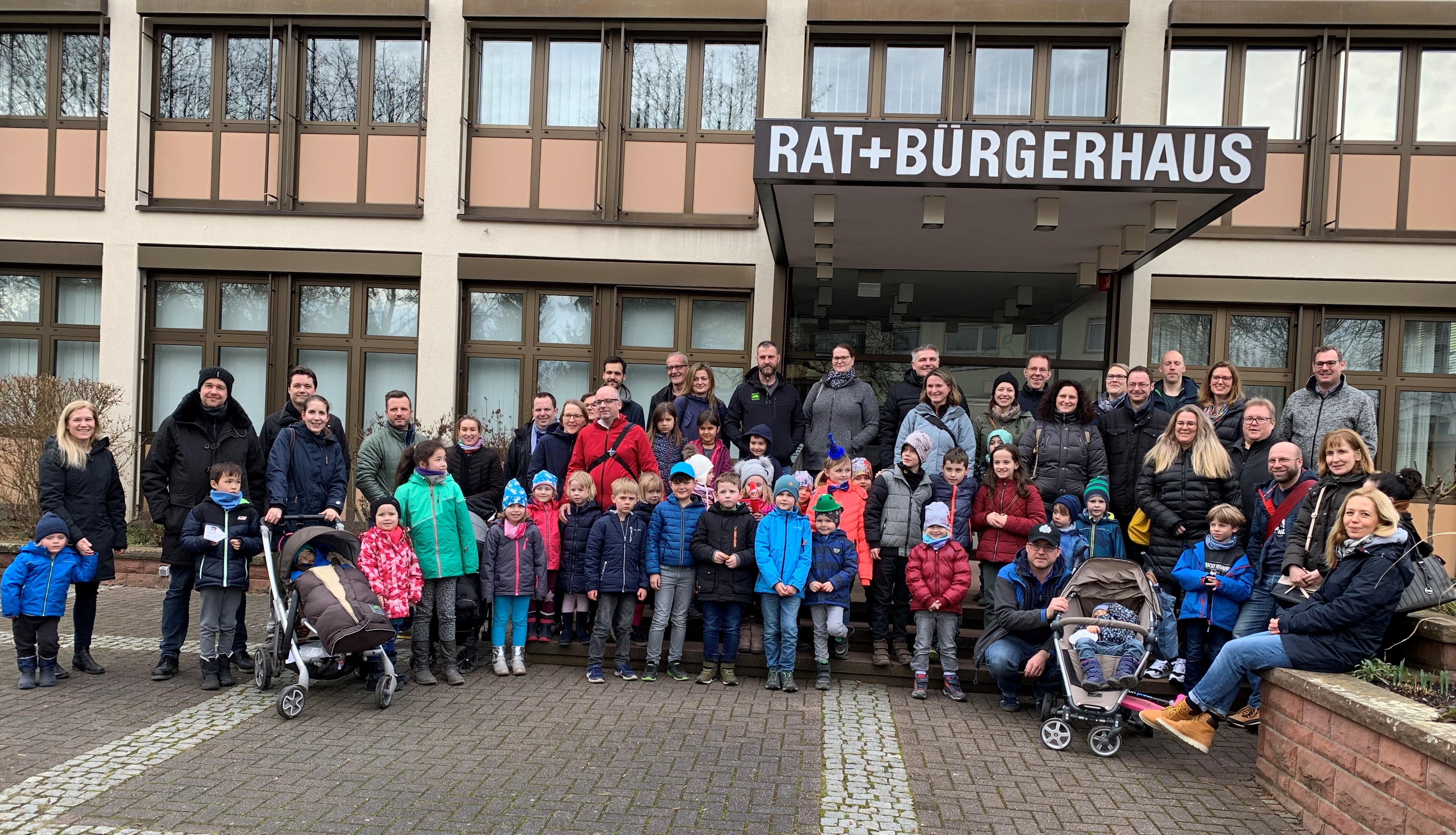 Alte und junge Bürger warm eingepackt vor dem Krifteler Rathaus.
