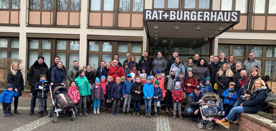 Alte und junge Bürger warm eingepackt vor dem Krifteler Rathaus.