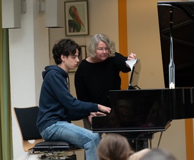 Schüler am Klavier mit Lehrerin.
