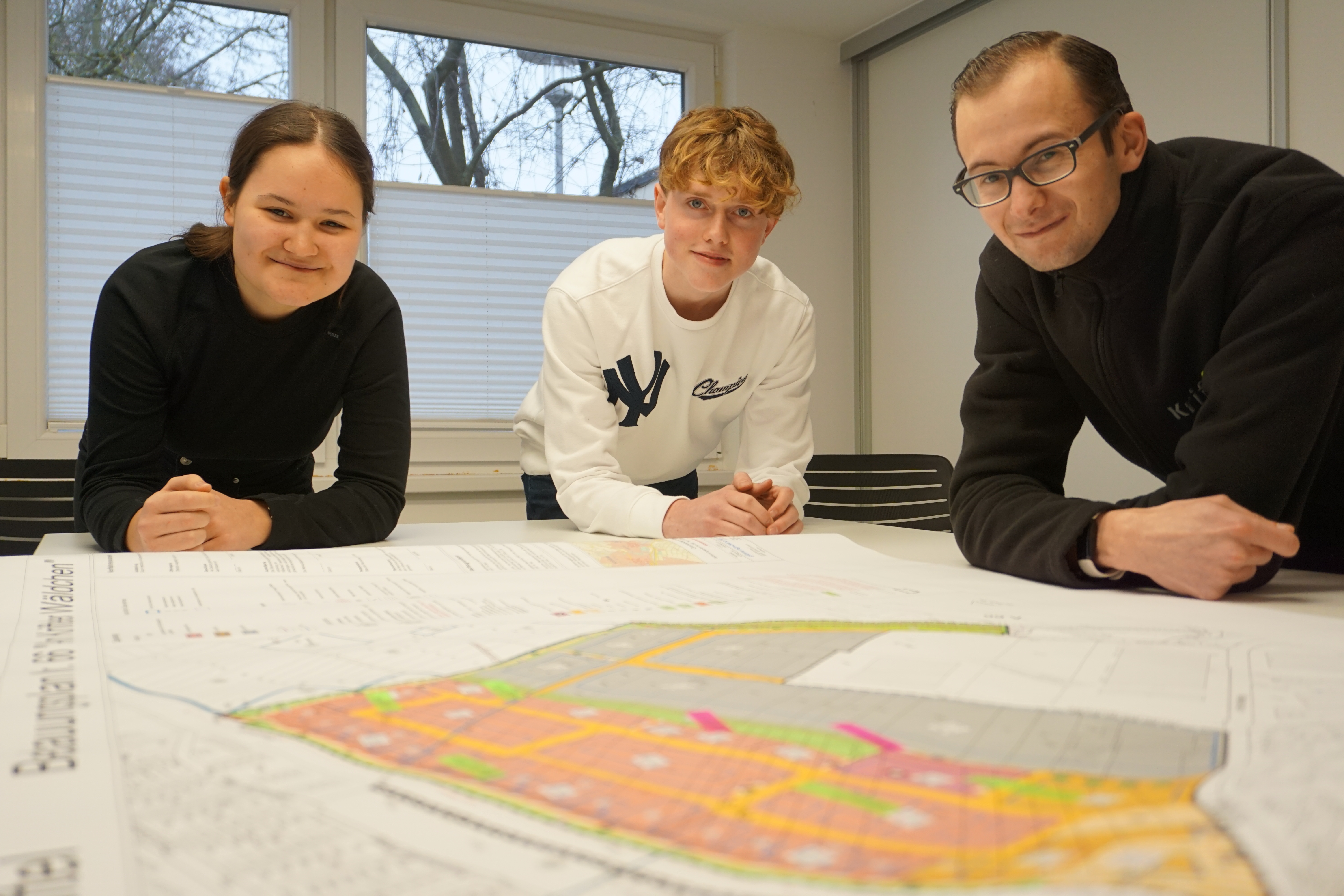 Die Praktikanten beugen sich über eine Karte.