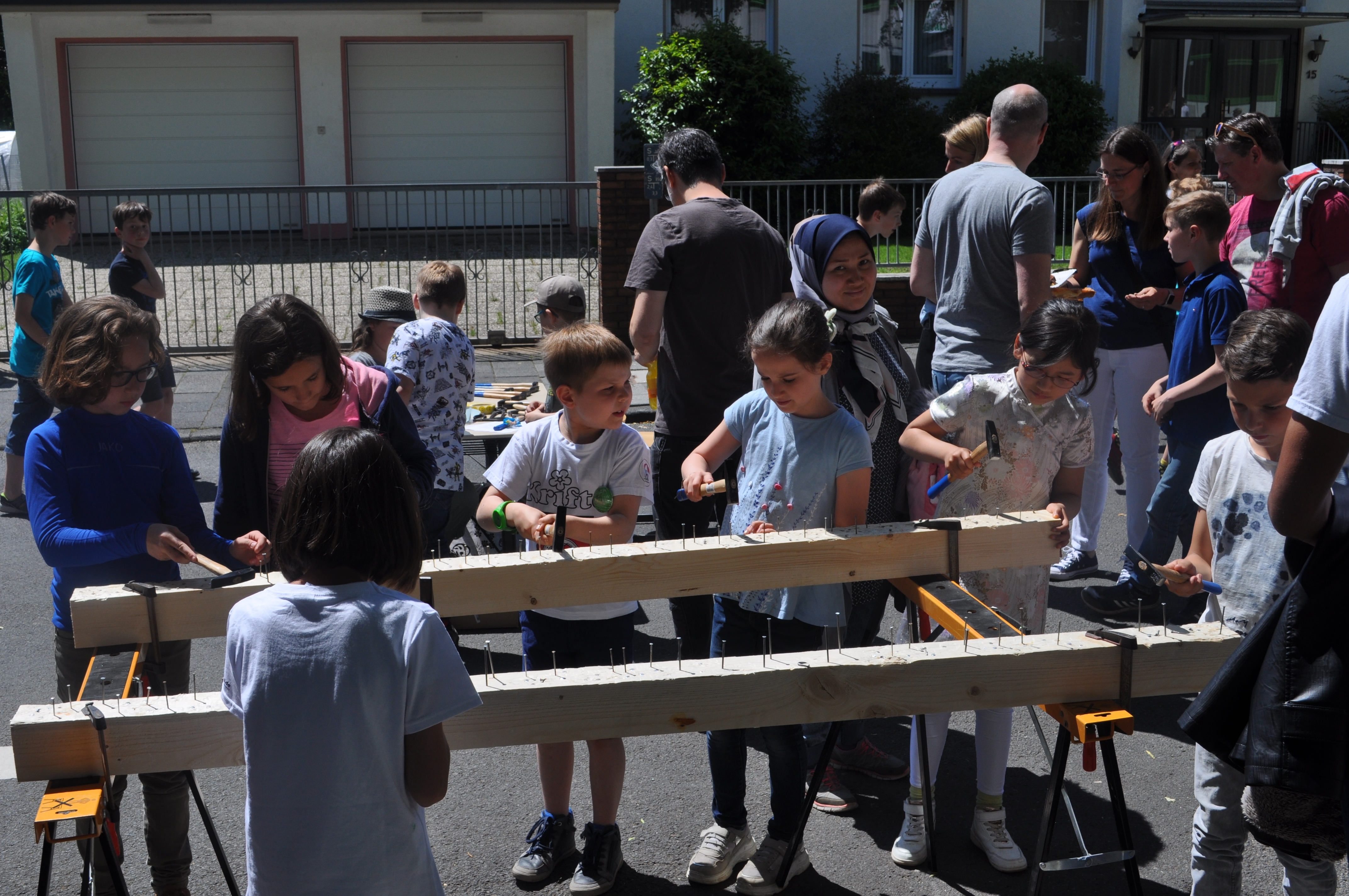 Kinder hämmern Nägel in einen Holzbalken.