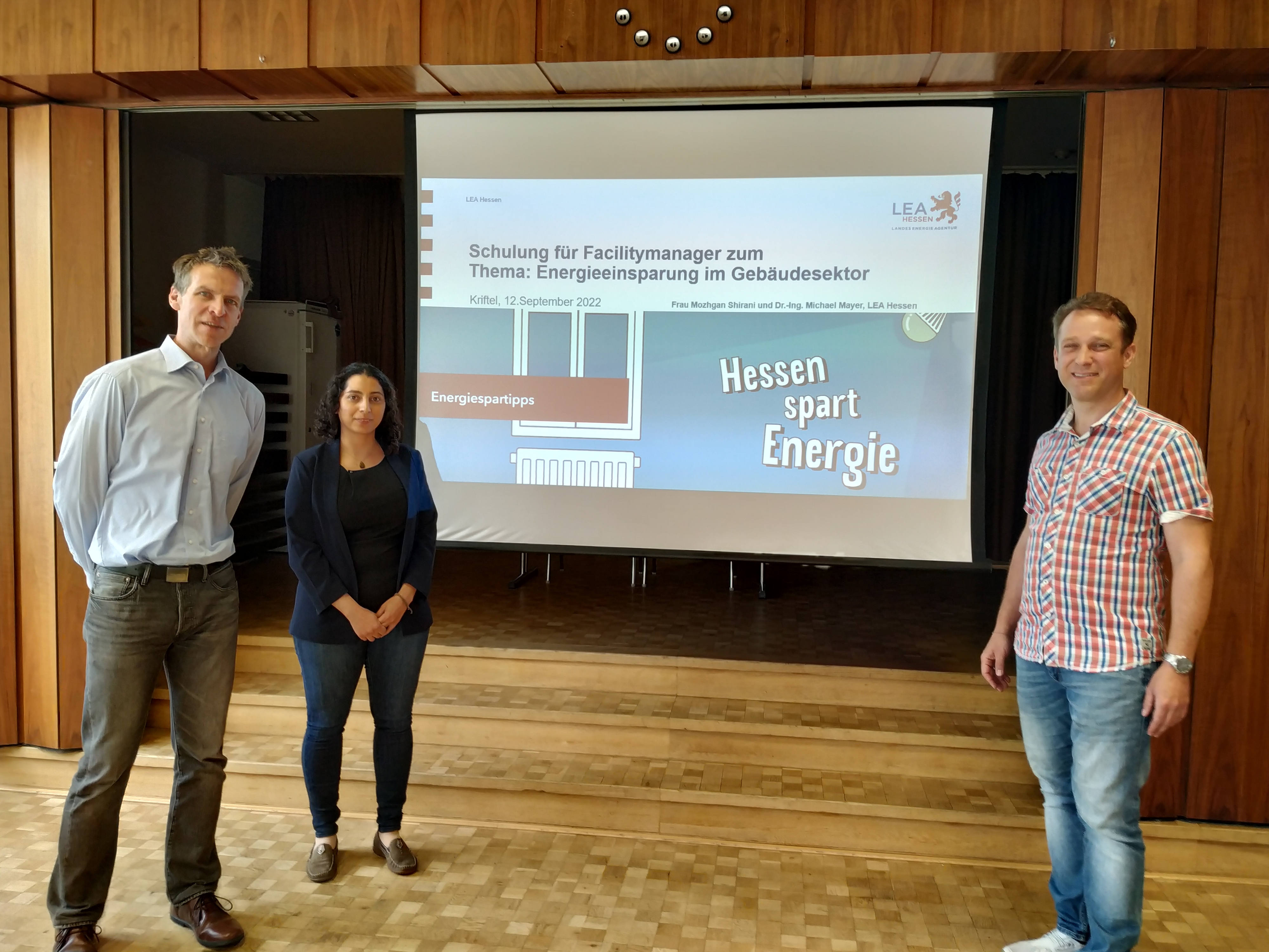 Die Referenten vor einer Leinwand.