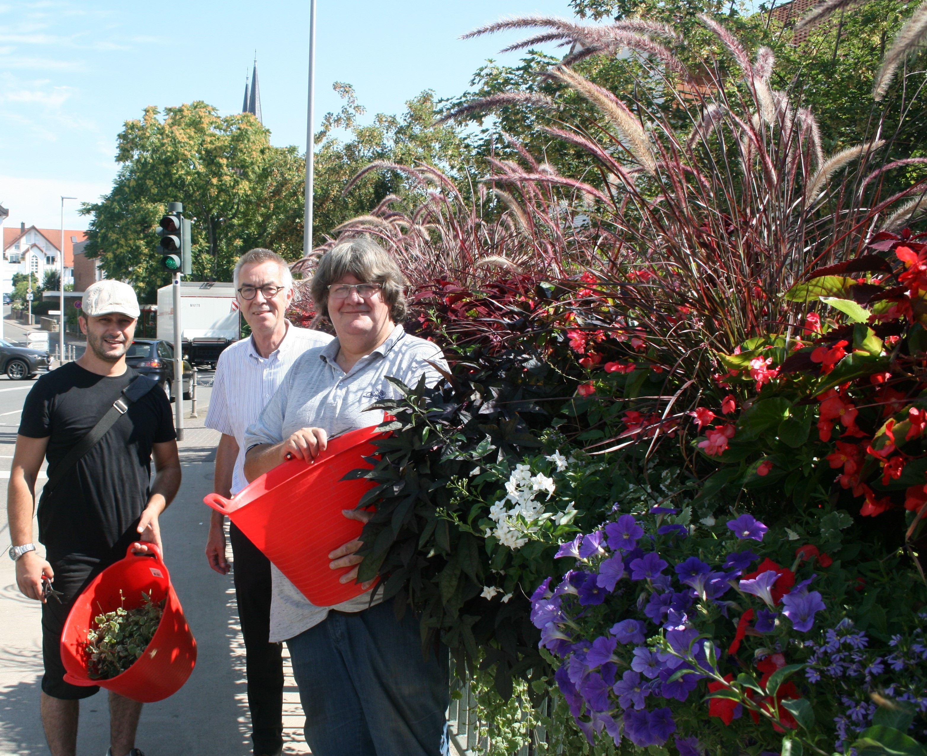 Das Pflanzteam mit dem Ersten Beigeordneten auf der Brücke vor den Blumenkästen.