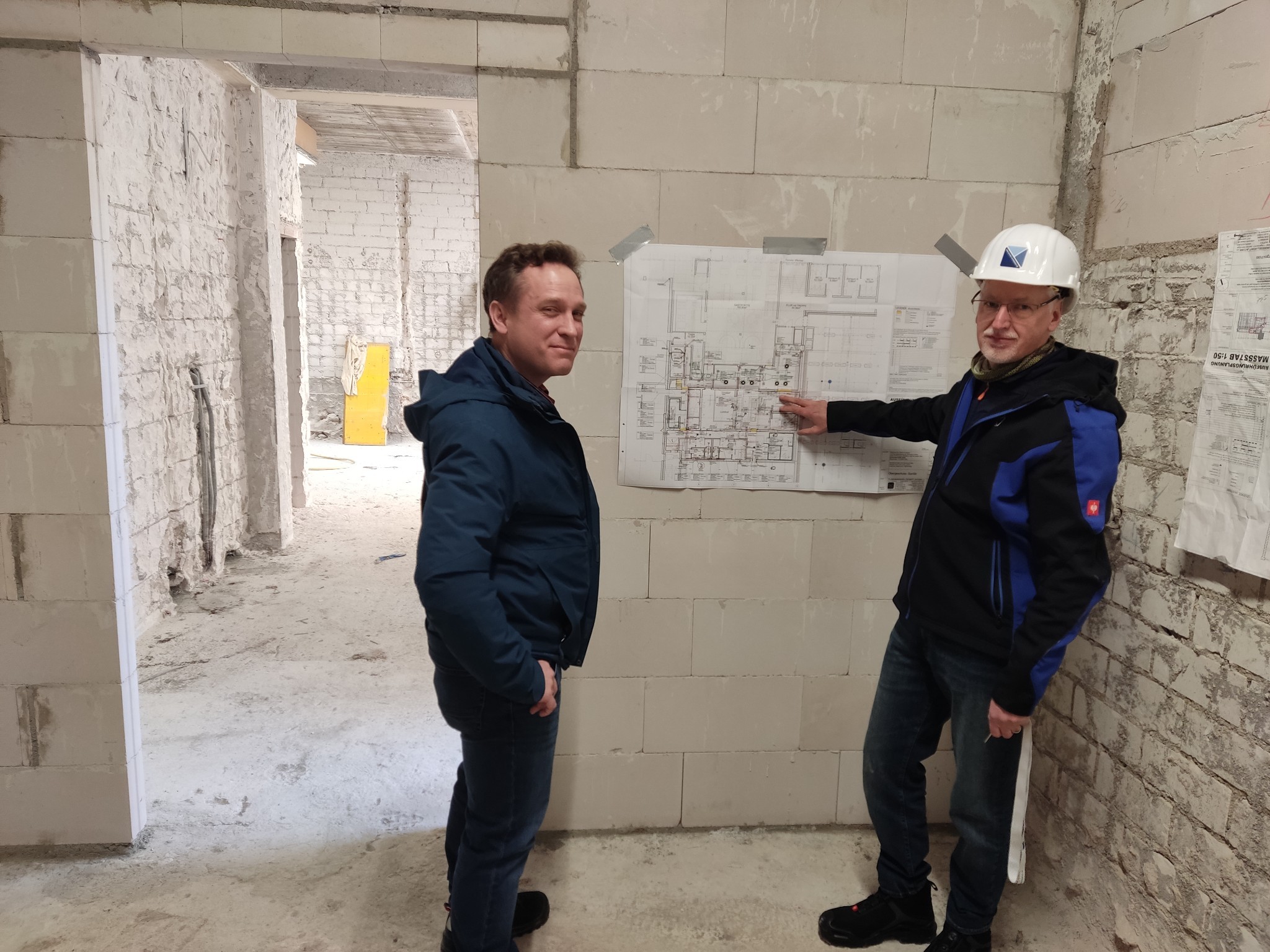 Mohr mit Architekt vor dem Bauplan.
