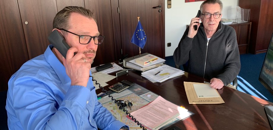 Seitz und Jirasek mit Telefonhörern in der Hand.