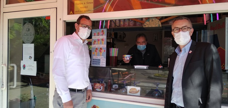 Bürgermeister Seitz und Erster Beigeordneter Jirasek mit Maske an der Eisdiele am Lindenplatz.