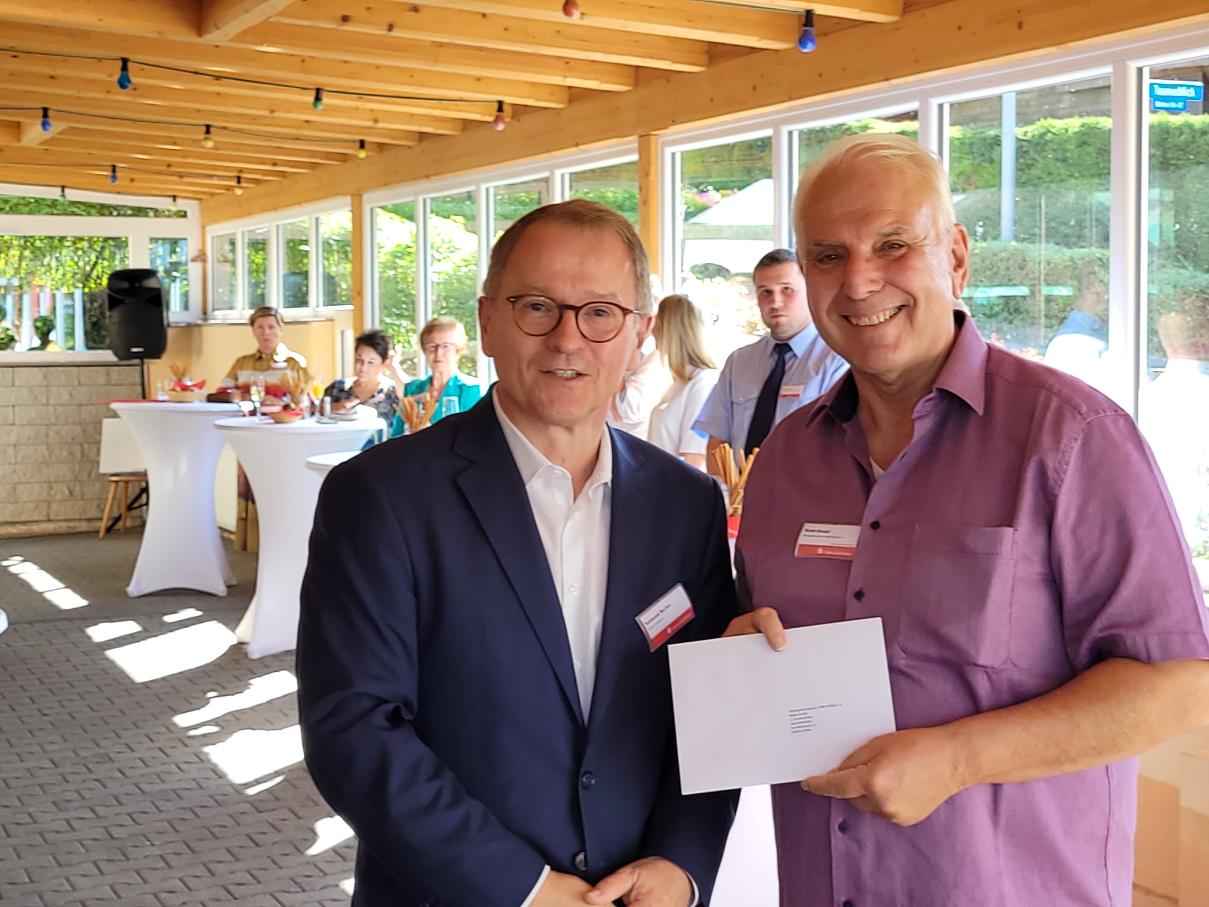 Vereinschef Bodo Knopf bekommt den Spendenscheck.