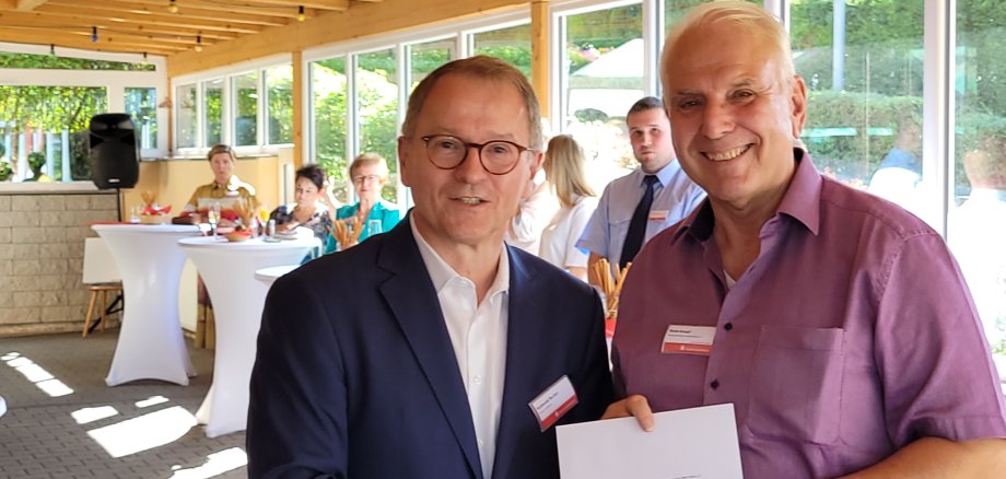 Vereinschef Bodo Knopf bekommt den Spendenscheck.