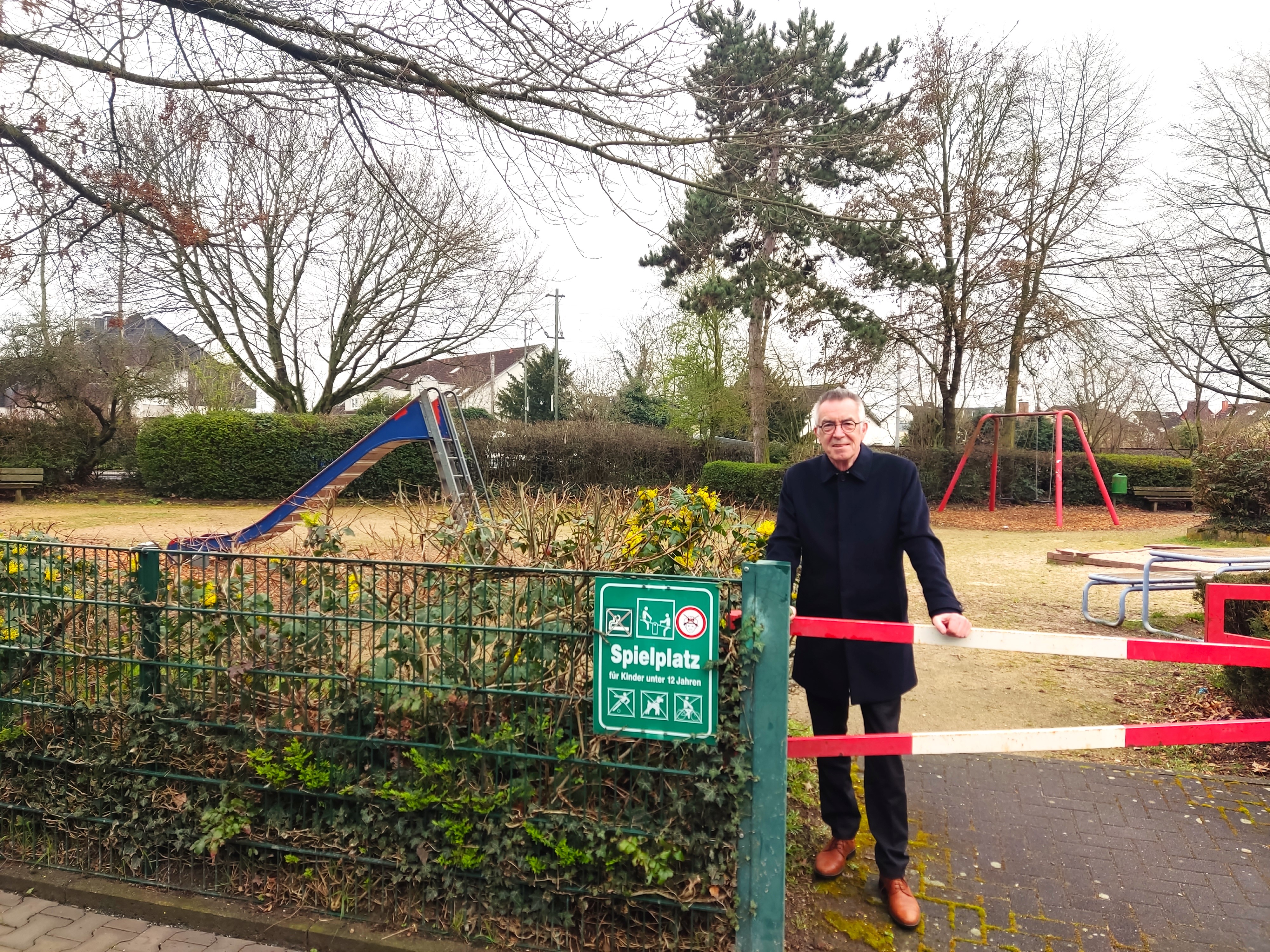 Jirasek hinter Spielplatzschild.