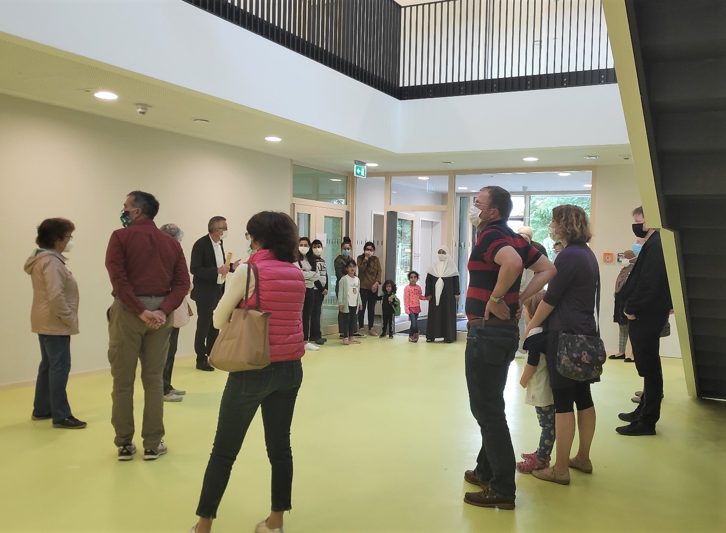 Eine Gruppe von Menschen mit Masken im Foyer der neuen Kita St. Vitus.