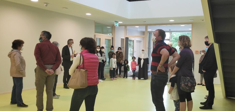 Eine Gruppe von Menschen mit Masken im Foyer der neuen Kita St. Vitus.