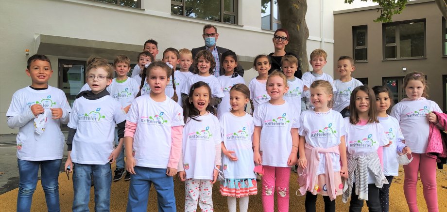 Die Klasse 1d mit Bürgermeister und Gemeinde-T-Shirts auf dem Schulhof.