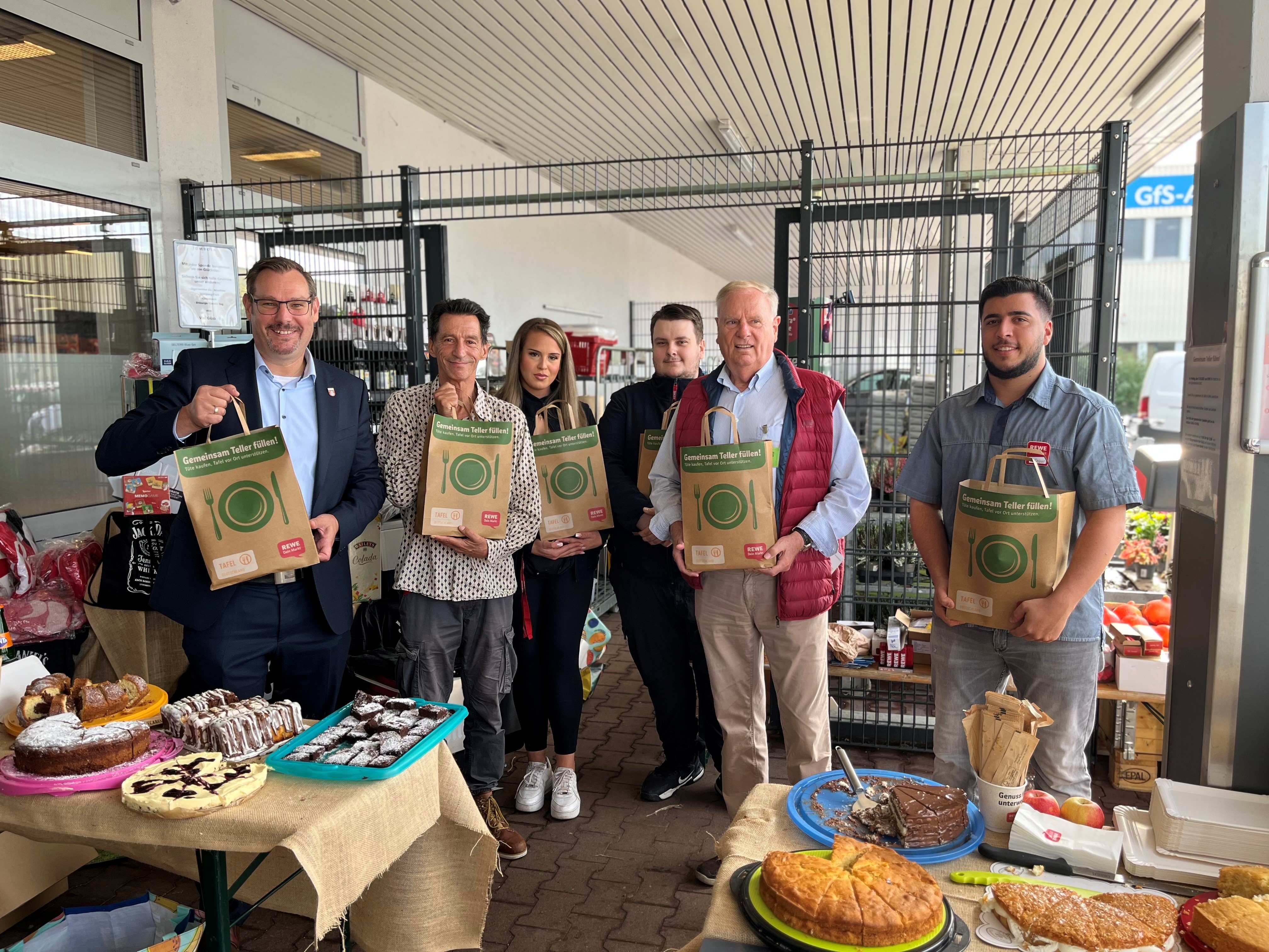 Bürgermeister, Tafel-Vertreter und Marktleitung mit Tafeltüten.