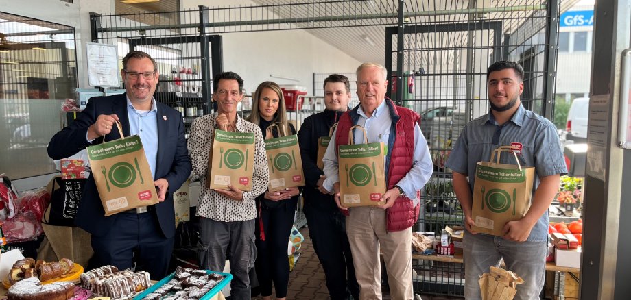 Bürgermeister, Tafel-Vertreter und Marktleitung mit Tafeltüten.