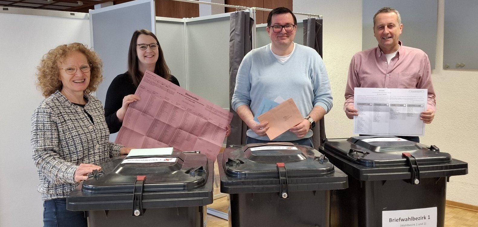 Das Team Wahlen hinter den Wahlurnen.