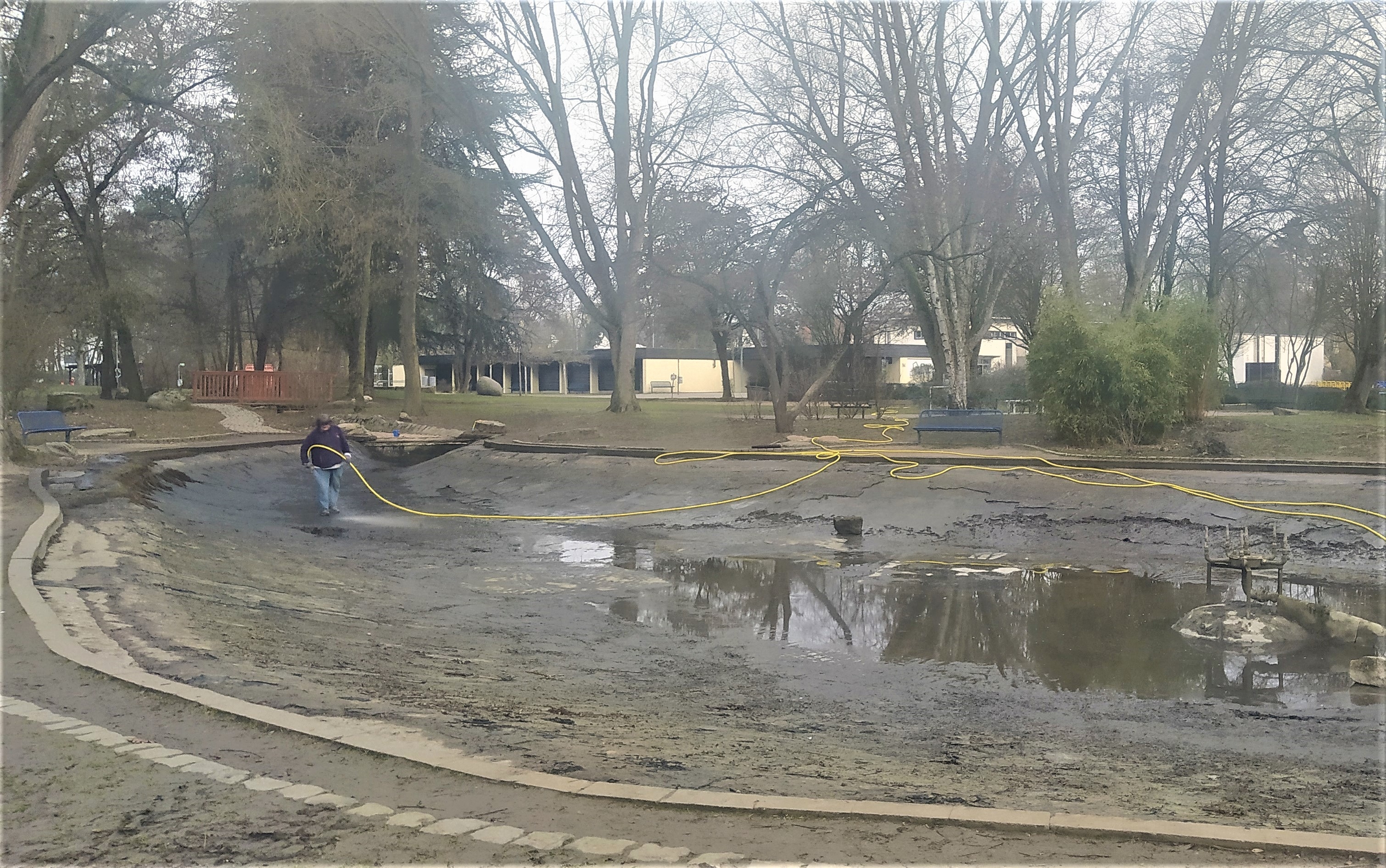 Eine dreckige Angelegenheit: Das leere Teichbecken wird ausgespritzt.