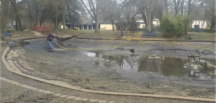 Eine dreckige Angelegenheit: Das leere Teichbecken wird ausgespritzt.
